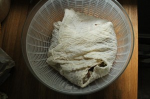 I wrap my bread in cheese cloth before spinning.  It comes open during spinning.