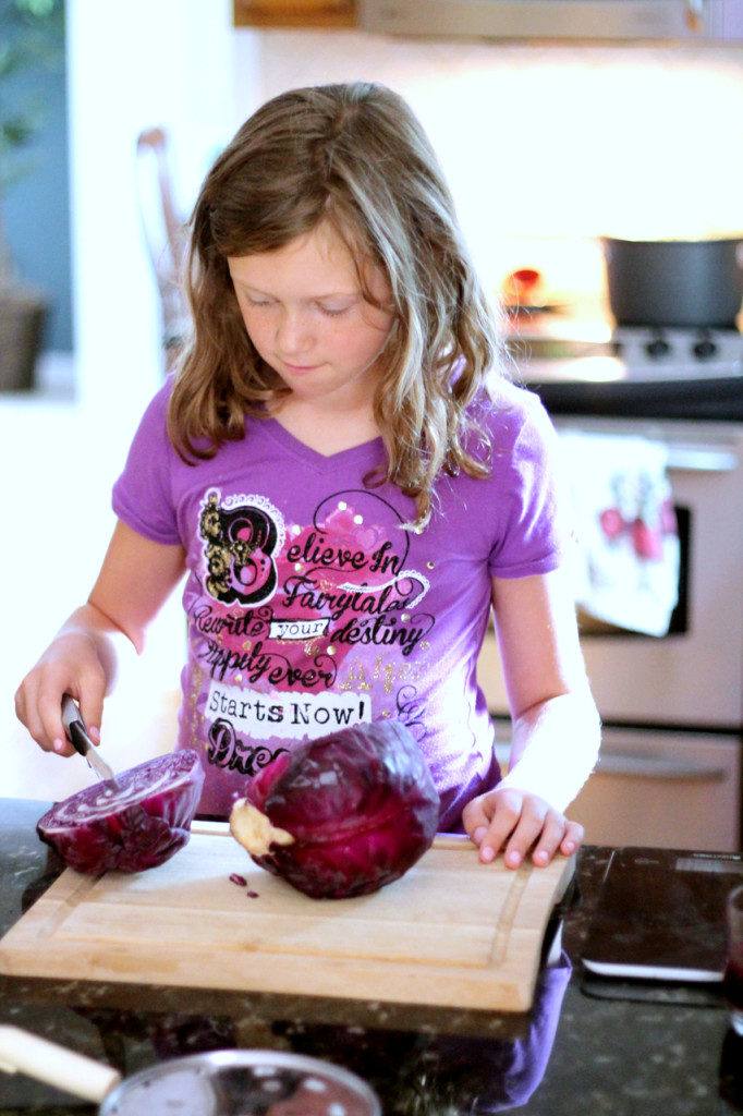 Ava holding a knife improperly over a wobbly head of cabbage. We got her corrected and chopping in no time!